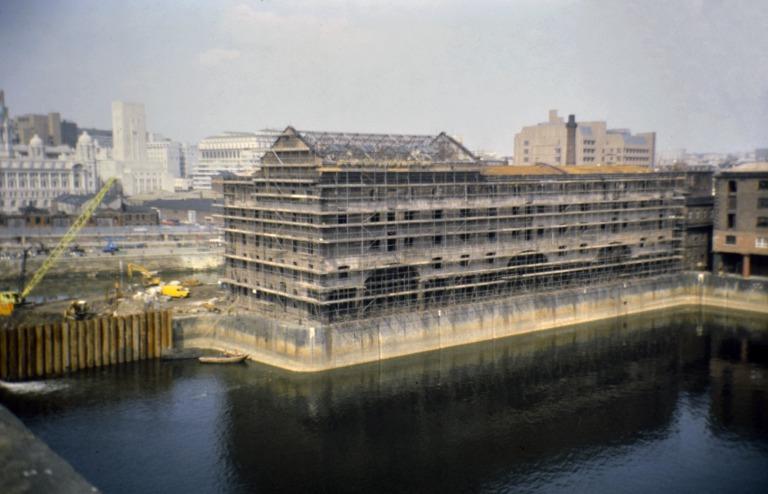 Photograph of renovation of Albert Dock, Liverpool, Block D, later Merseyside Maritime Museum west and south elevations with cold storage roof addition, all scaffolded. card