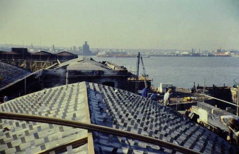 Photograph of renovation of Albert Dock, Liverpool, Block D, later Merseyside Maritime Museum, roofs looking west along north elevation with stainless steel roof cleats to receive cork roof insulation in view and north west corner with cork being installe card