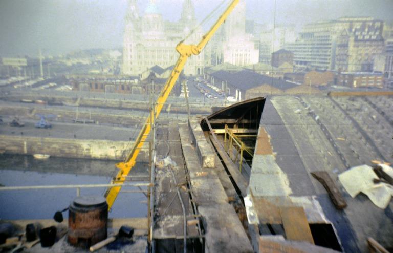 Photograph of renovation of Albert Dock, Liverpool, Block D, later Merseyside Maritime Museum, north east corner of roof with stainless steel roof cleats to retain cork roof insulation and west hipped end showing original wrought iron roof sheets removed. card