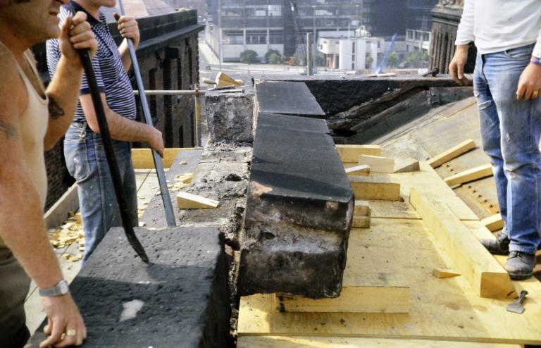 Photograph of renovation of Albert Dock, Liverpool, Block D, later Merseyside Maritime Museum, removing sandstone copings on the roof parapet to south east corner. card