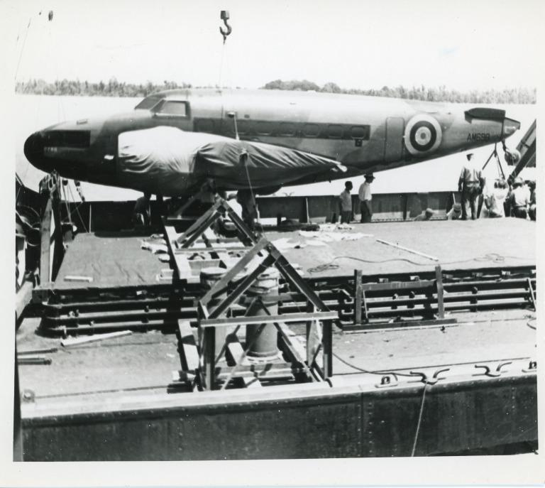 Photograph of dock workers loading aeroplanes onto a ship in New Orleans during WWII card